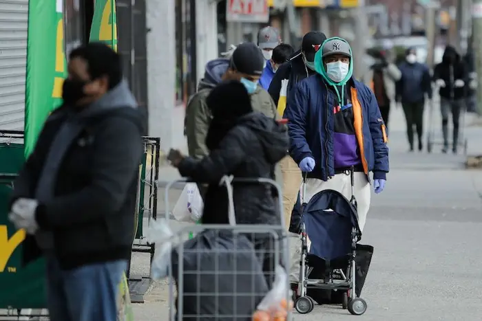 Patrons wait in line for a supermarket in Corona, a Queens community that's been heavily struck by the COVID-19 virus.